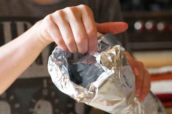 Fold over the ends of the foil so the edge is extra thick. This is going to be the heaviest portion of the cornucopia. Once you have it all folded, stretch out the edges of the foil by pulling it up with your hands so you have a wide opening.